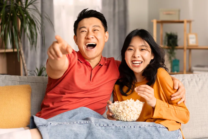 Couple laughing and eating popcorn