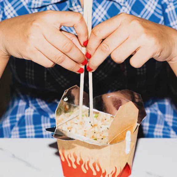 Hands of a woman eating noodles